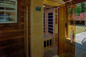 Ein Saunaraum mit Holzvertäfelung, einer Glastür und einem kleinen Fenster.