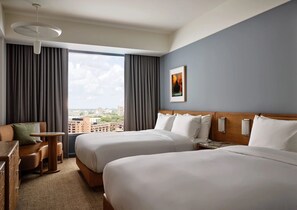 A hotel room with two beds, a desk, a chair, and a view of the city. - 2 Queen Beds near Allston Square | Near MBTA Transit | Group Stay near Harvard (Boston)