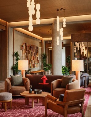 Un hall d’entrée moderne avec des canapés en cuir, une table basse et des luminaires suspendus.