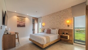 Una habitación de hotel moderna con una cama grande, un escritorio con hervidor, vista al exterior y una lámpara de pared.