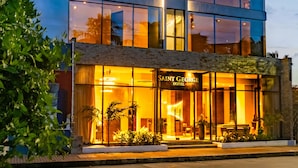 A modern hotel with multiple floors, large windows, and a well-lit entrance. - Saint George Hotel (San Andrés)