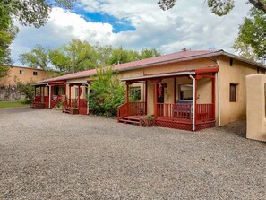 Two small, single-story buildings with red railings and a gravel ground.