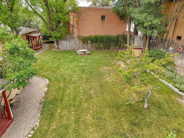 A well-maintained backyard with a lawn, a wooden deck, and a small garden area.