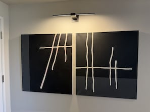 Zwei große schwarze Gemälde mit weißen Linien an einer weißen Wand.