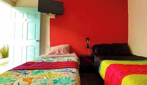 A room with two beds, a red wall, a door, and a television mounted above the door. - Spacious & Cozy Suites with pool (Cabo San Lucas)