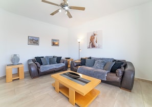 A modern living room with two sofas, a coffee table, and a ceiling fan. - Large 4 Bedroom Villa Featuring Hot Tub, Private Pool & Air Con (Playa Blanca)