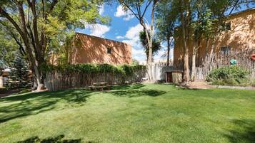A well-maintained backyard with a grassy lawn, a wooden bench, and a small shed.