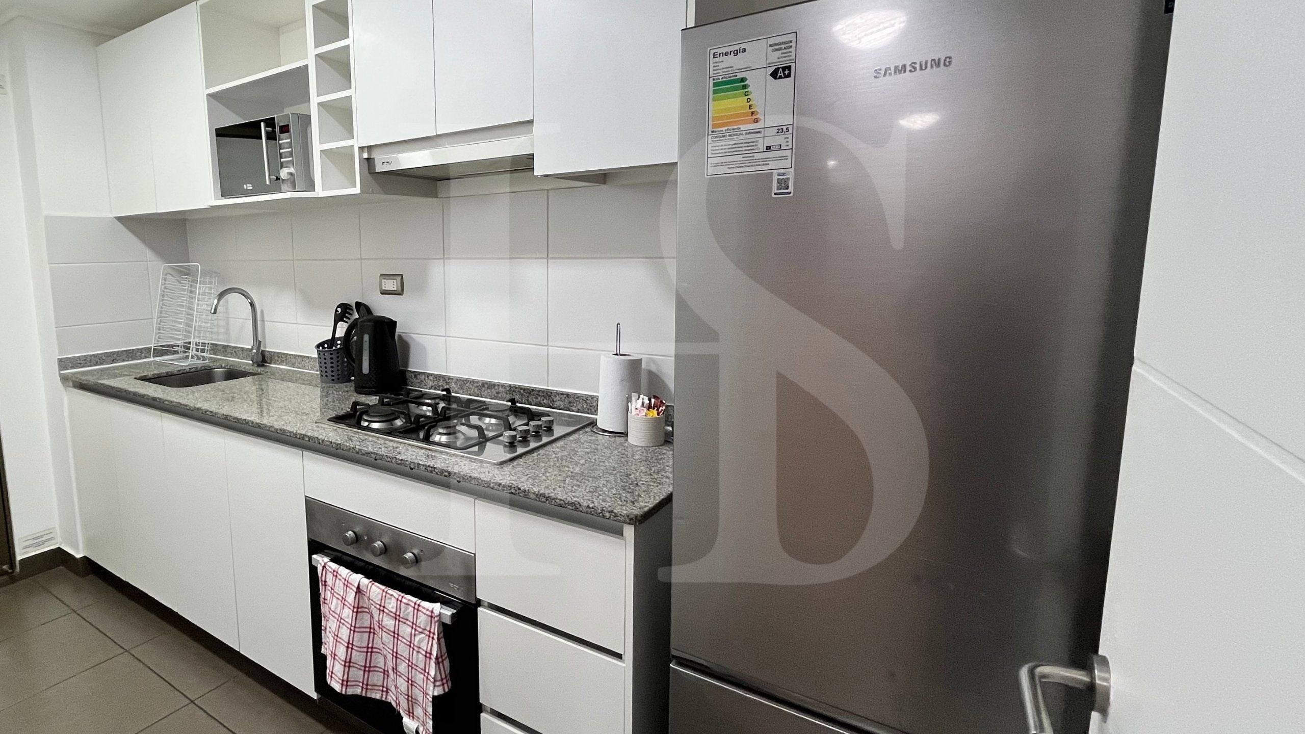 Una cocina moderna con armarios blancos, un refrigerador de acero inoxidable, una estufa a gas y un lavavajillas.