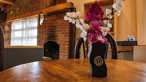 A wooden table with a vase of flowers in the center. - CABAÑAS ALDEA GOTICA (Amealco de Bonfil)