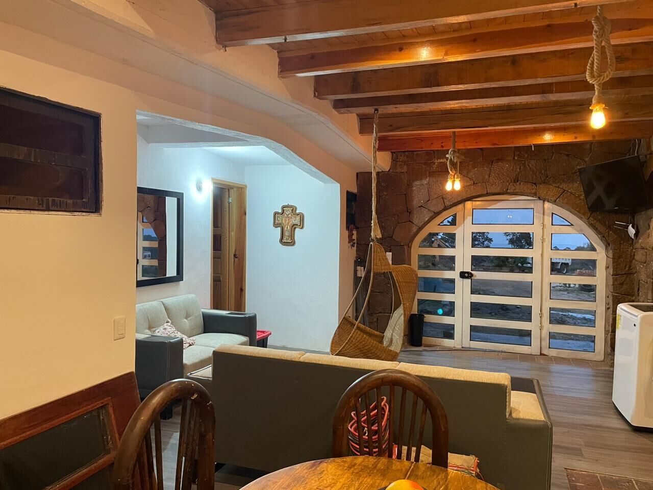 Een eethoek met een tafel, stoelen en een hanglamp.