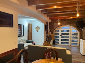A dining area with a table, chairs, and a hanging light fixture.