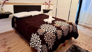 A bedroom with a bed, bedside tables, and a window with curtains. - CABAÑAS ALDEA GOTICA (Amealco de Bonfil)