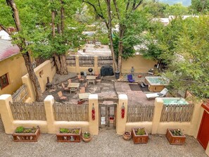 Une cour avec un jacuzzi, des sièges d’extérieur et des jardinières.