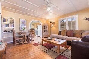 A cozy living room with a wooden coffee table, a sofa, and a bookshelf.