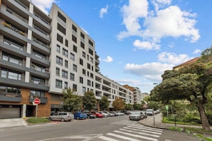 A multi-story residential building with balconies, a pedestrian crossing, and parked cars. - AC 2 room apartment, Old City, Blumentalska (Bratislava)