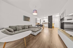 A modern living room with a sectional sofa, a dining area, and a kitchen. - AC 2 room apartment, Old City, Blumentalska (Bratislava)