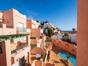 A coastal residential area with terraced buildings, a swimming pool, and a clear view of the sea. - Apartment  by Interhome (Nerja)