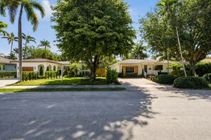 A residential street with houses, palm trees, and a clear sky. - Fox Eden Resort 8Bd Pool Spa Oasis (Fort Lauderdale)