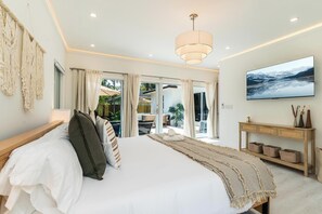 A modern bedroom with a large bed, a television, and a view of the outdoors. - Fox Eden Resort 8Bd Pool Spa Oasis (Fort Lauderdale)
