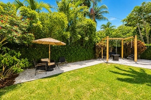 A patio with a wooden pergola, outdoor furniture, and a thatched umbrella. - Fox Eden Resort 8Bd Pool Spa Oasis (Fort Lauderdale)