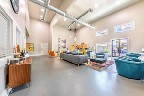 A spacious living area with a grey sofa, blue armchairs, and a wooden side table. - Riverside escape | Pool & Gym | Free parking (Austin)