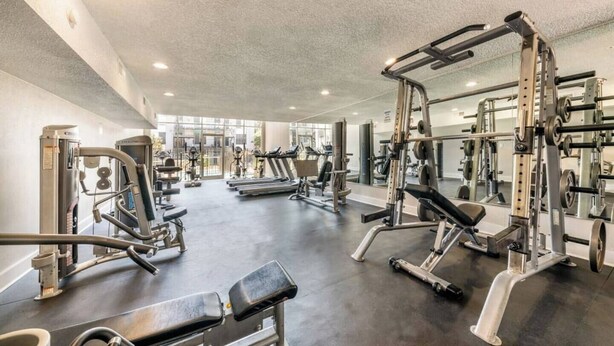 Et fitnesscenter med forskellig træningsudstyr, herunder løbebånd og styrkemaskiner.