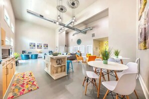 A spacious living area with a kitchen, dining table, and seating arrangements. - Riverside escape | Pool & Gym | Free parking (Austin)