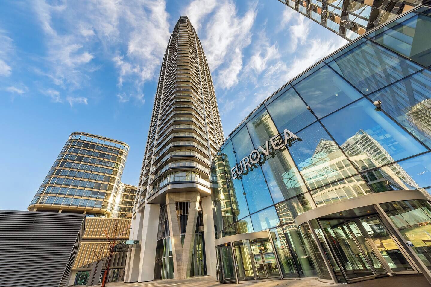 A modern building with a prominent curved facade and the name 'EUROVEA' on the glass.