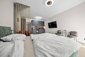 A modern hotel room with two beds, a kitchenette, a TV, and a small dining area. - Metropolis Downtown, Balcony, AC & Free Parking (Bratislava)