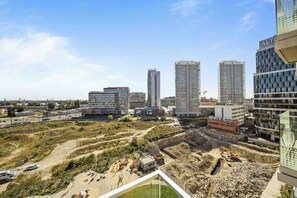 A cityscape with modern high-rise buildings, a construction site, and a clear sky. - Metropolis Downtown, Balcony, AC & Free Parking (Bratislava)