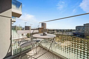 A balcony with a table and chairs, a potted plant, and a view of the cityscape. - Metropolis Downtown, Balcony, AC & Free Parking (Bratislava)