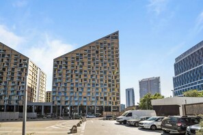 A modern multi-story building with a distinctive triangular roof, surrounded by other high-rise buildings. - Metropolis Downtown, Balcony, AC & Free Parking (Bratislava)