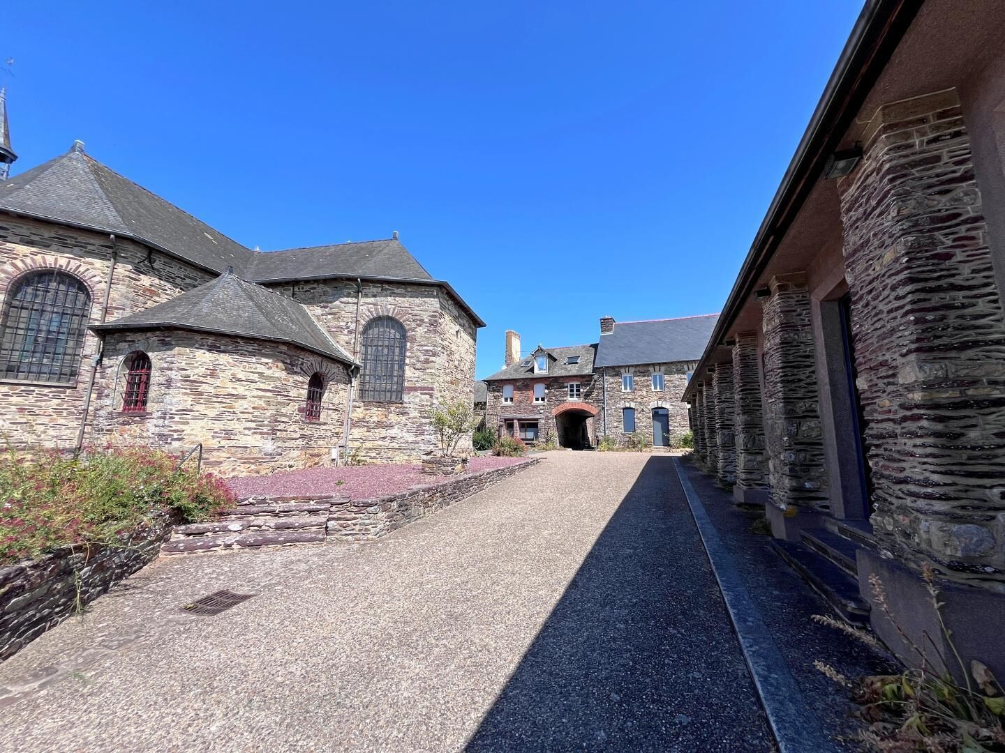 Un bâtiment en pierre doté d’une cour intérieure, d’une galerie couverte et d’un style architectural traditionnel.