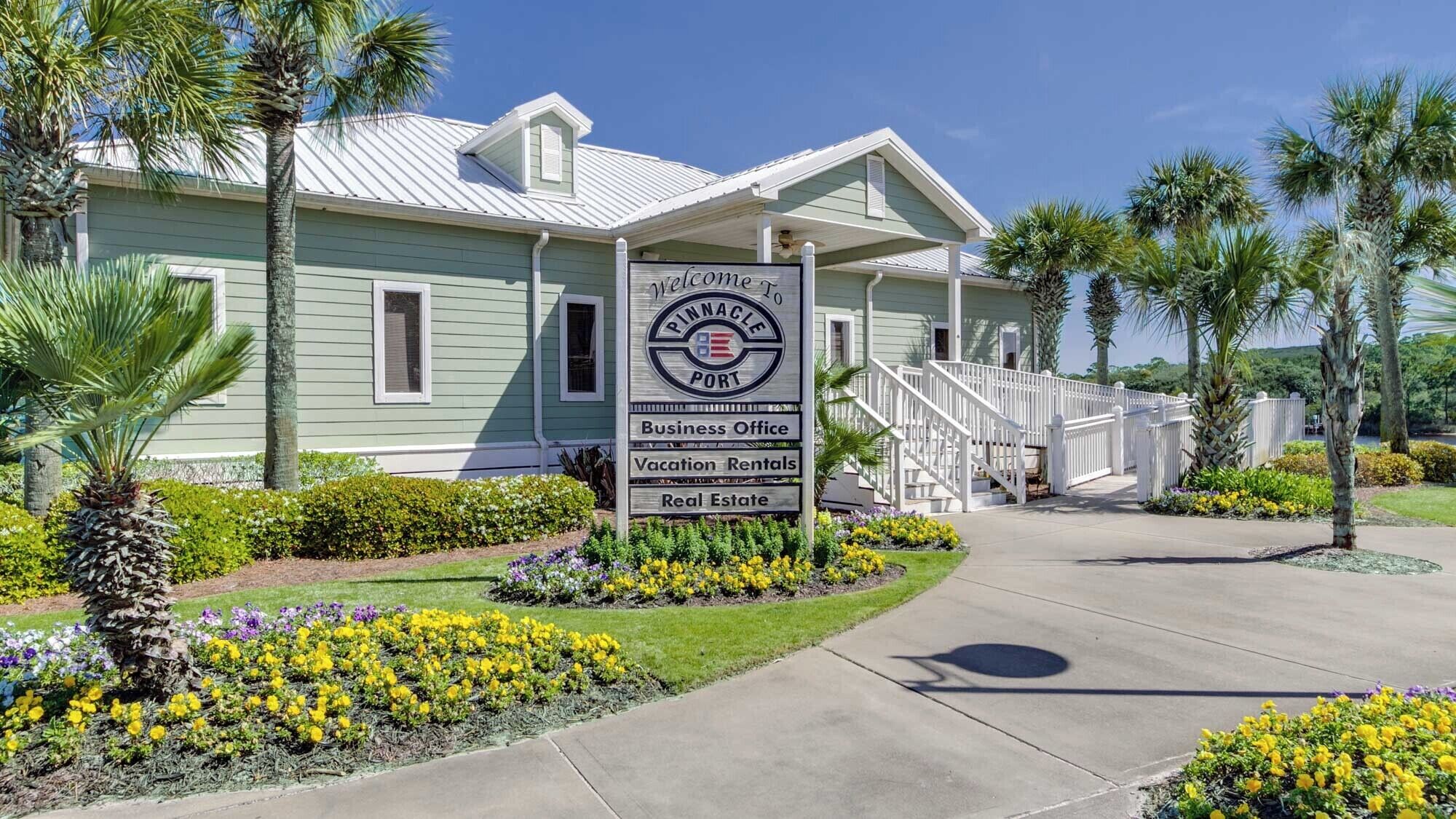 A building with a sign indicating it offers business office, vacation rentals, and real estate services.