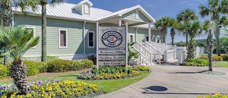 A building with a sign indicating it offers business office, vacation rentals, and real estate services.