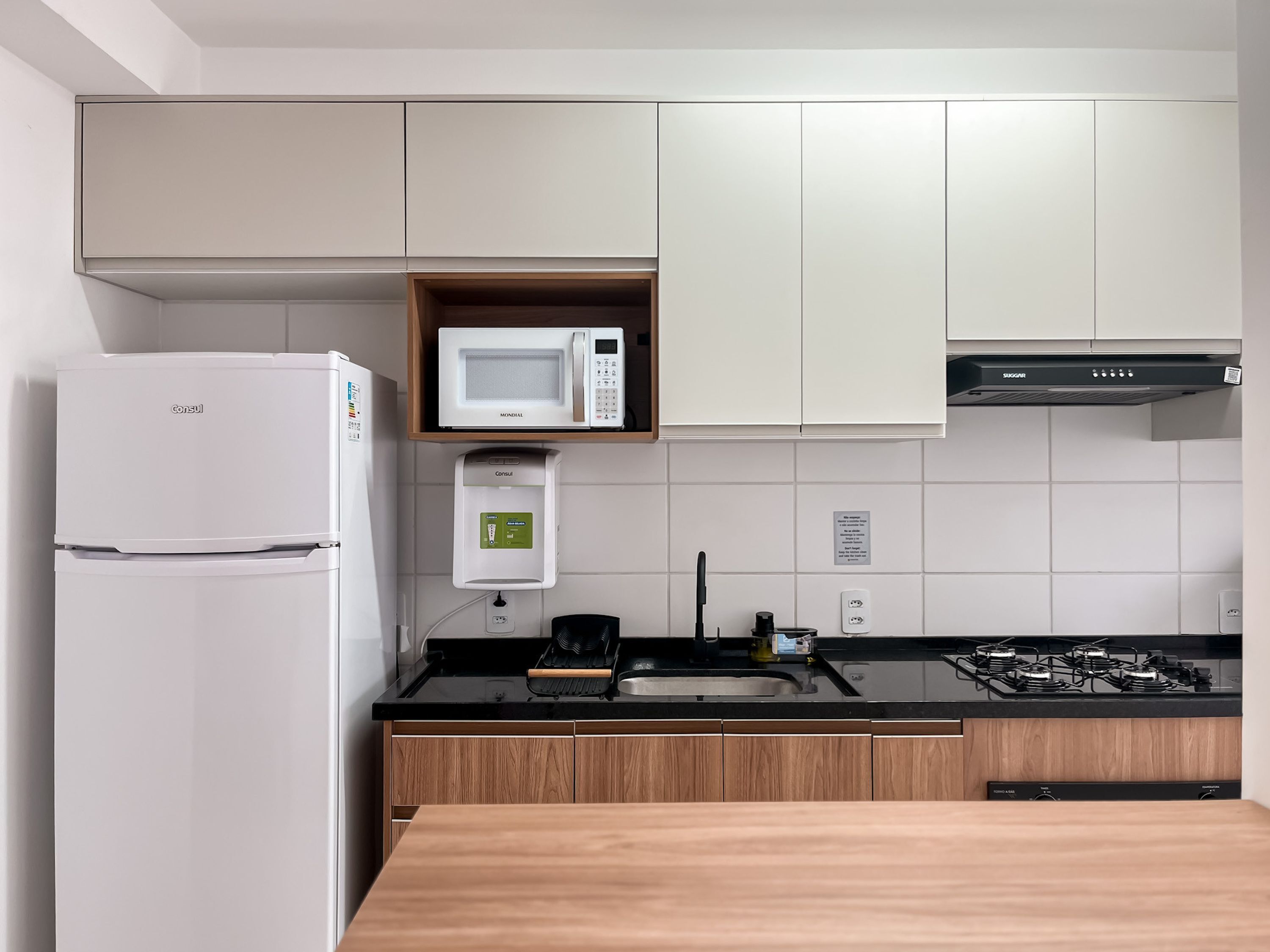 Eine moderne Küche mit Kühlschrank, Mikrowelle und Herd.
