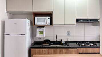Eine moderne Küche mit Kühlschrank, Mikrowelle und Herd.