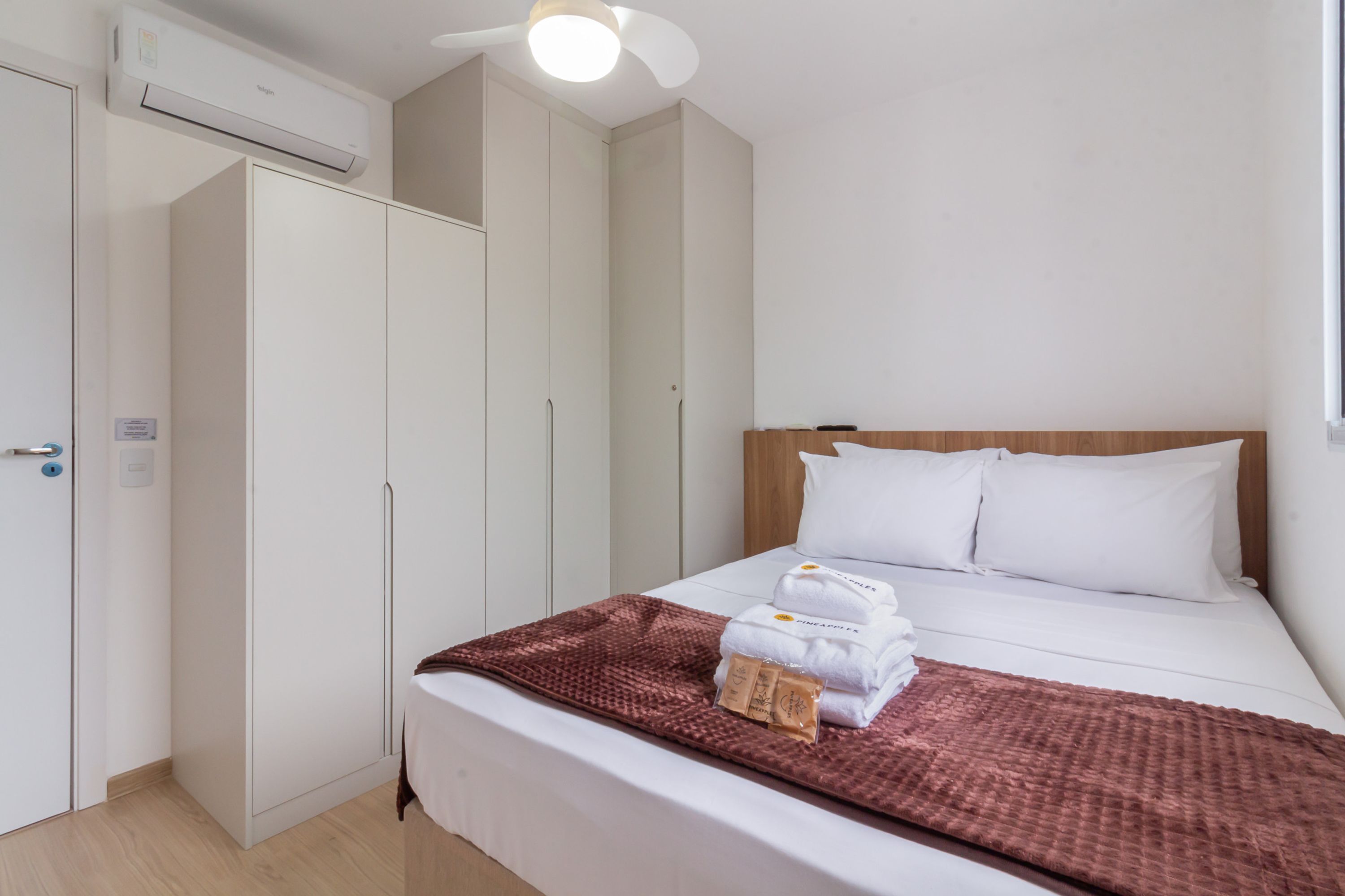 Ein Hotelzimmer mit Bett, Kleiderschrank und Klimaanlage.