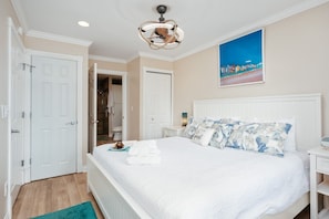 A hotel room with a bed, a bathroom, and a hallway. - Coastal Duo 108 & 109 | Beachfront | Near Downtown + Tart Trail (Traverse City)