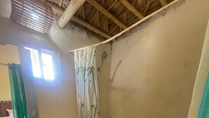 Ein Badezimmer mit Toilette, Waschbecken und einer Duschvorhang aus Bambus.