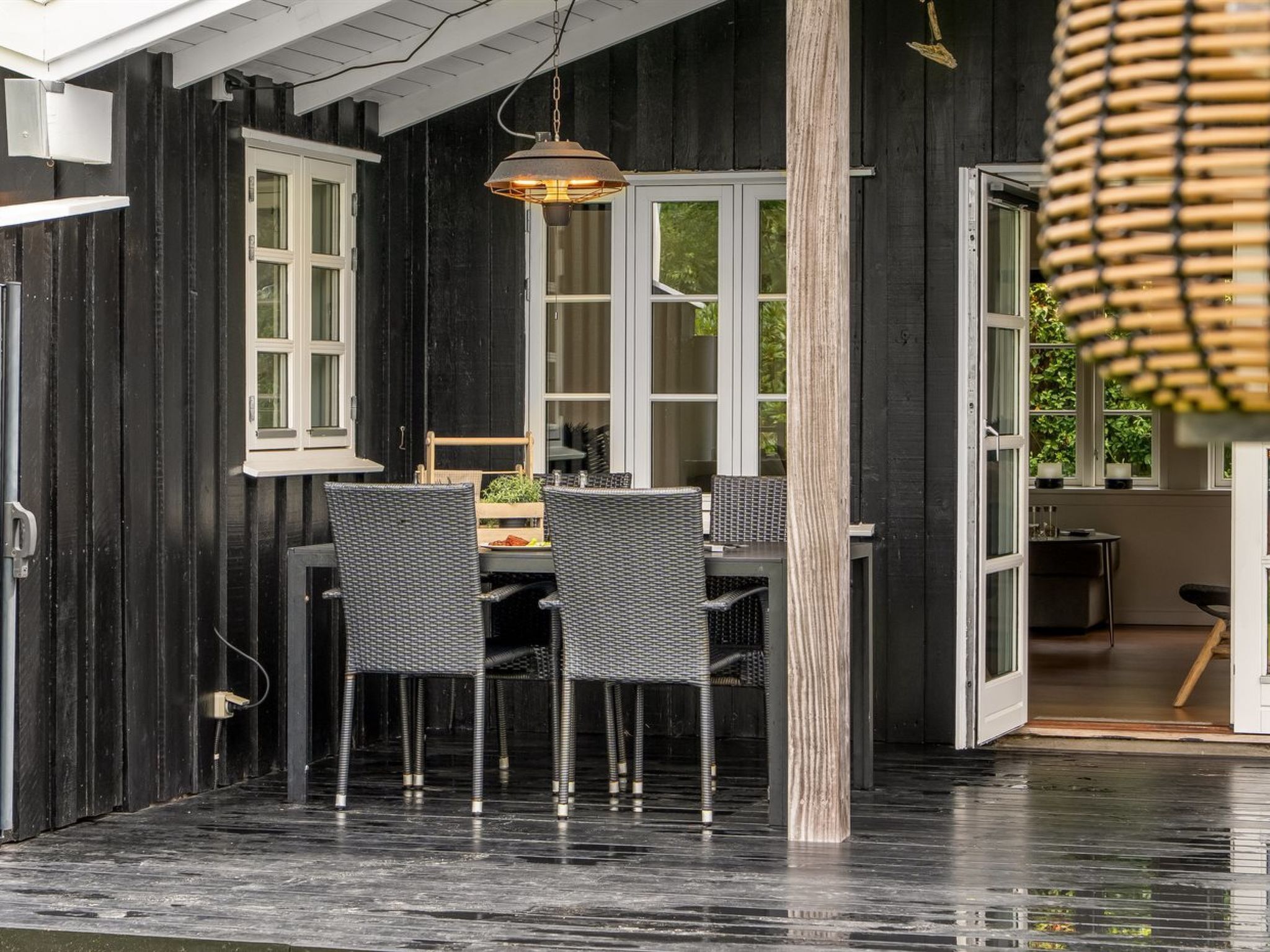 Comedor con una mesa y sillas, una lámpara colgante y vista al exterior.