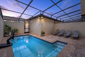 An indoor swimming pool with a tiled deck, lounge chairs, and potted plants. - 5BR Kissimmee | Pool & Lazy River | 13 Min Disney (Kissimmee)