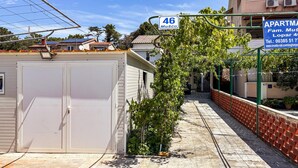 Un barrio residencial con un edificio identificado como '46 Musco' y un letrero que dice 'APARTAMENTO'.