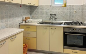 A kitchen with a gas stove, double sink, and a built-in oven. - Stunning apartment in Lopar with house sea view (Lopar)
