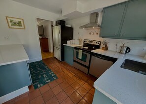 Une cuisine équipée d’un réfrigérateur, d’une cuisinière, d’un four et d’un lave-vaisselle.