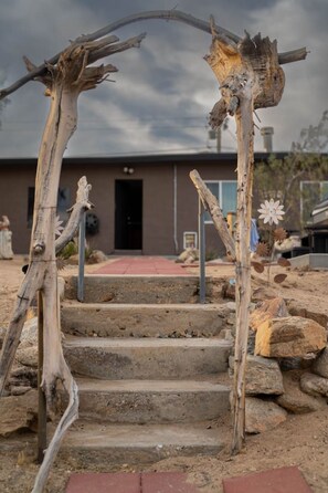 A rustic wooden archway leading to a building with a red door. - Aster Abode W/ Hot Tub & Game Room - 5 Mi to Park (Joshua Tree)