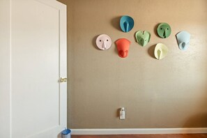 Ein Zimmer mit einer beige gestrichenen Wand, einer weißen Tür und einer kleinen Mülltonne.