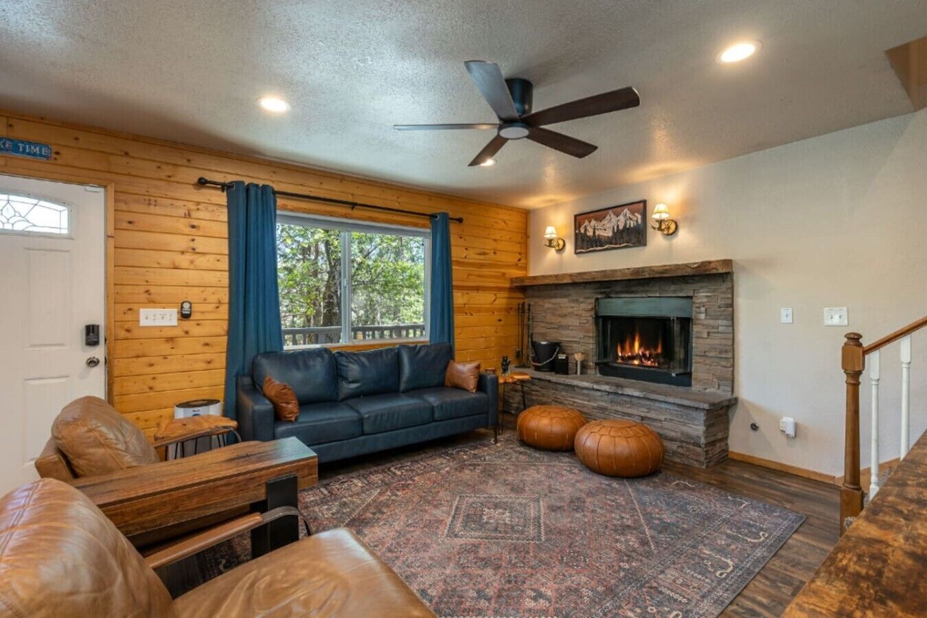 A cozy living room with a fireplace, a sofa, a coffee table, and a rug.