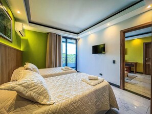 A hotel room with two beds, a flat-screen TV, and a sliding glass door leading to a balcony. - Cozy & elegante 2-bedroom apartment (Santa Cruz de la Sierra)