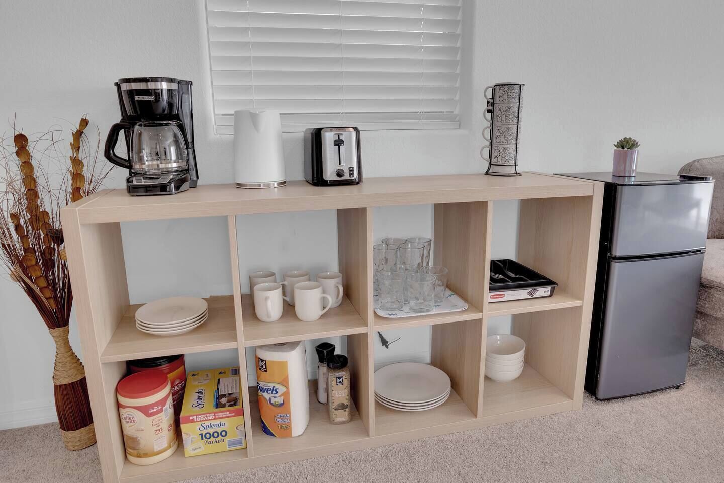 Una kitchenette equipada con cafetera, tostadora y refrigerador.